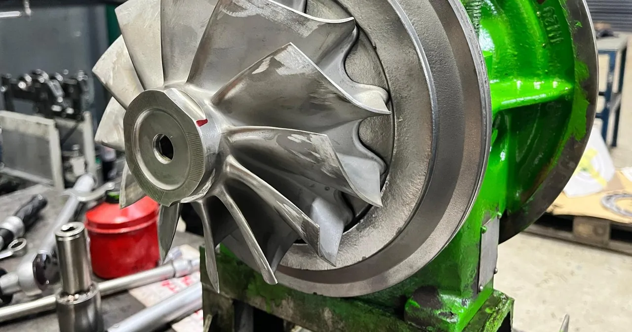 Sample image: a compressor wheel in a green turbocharger housing, with tools in the background
